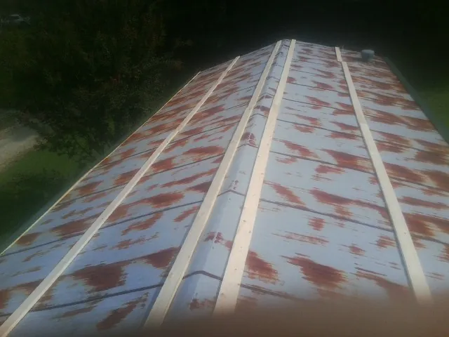 Rusted metal roof panels with new wood purlins before replacement — Storm Damage Roof Repair in Clute by Roofing Brothers
